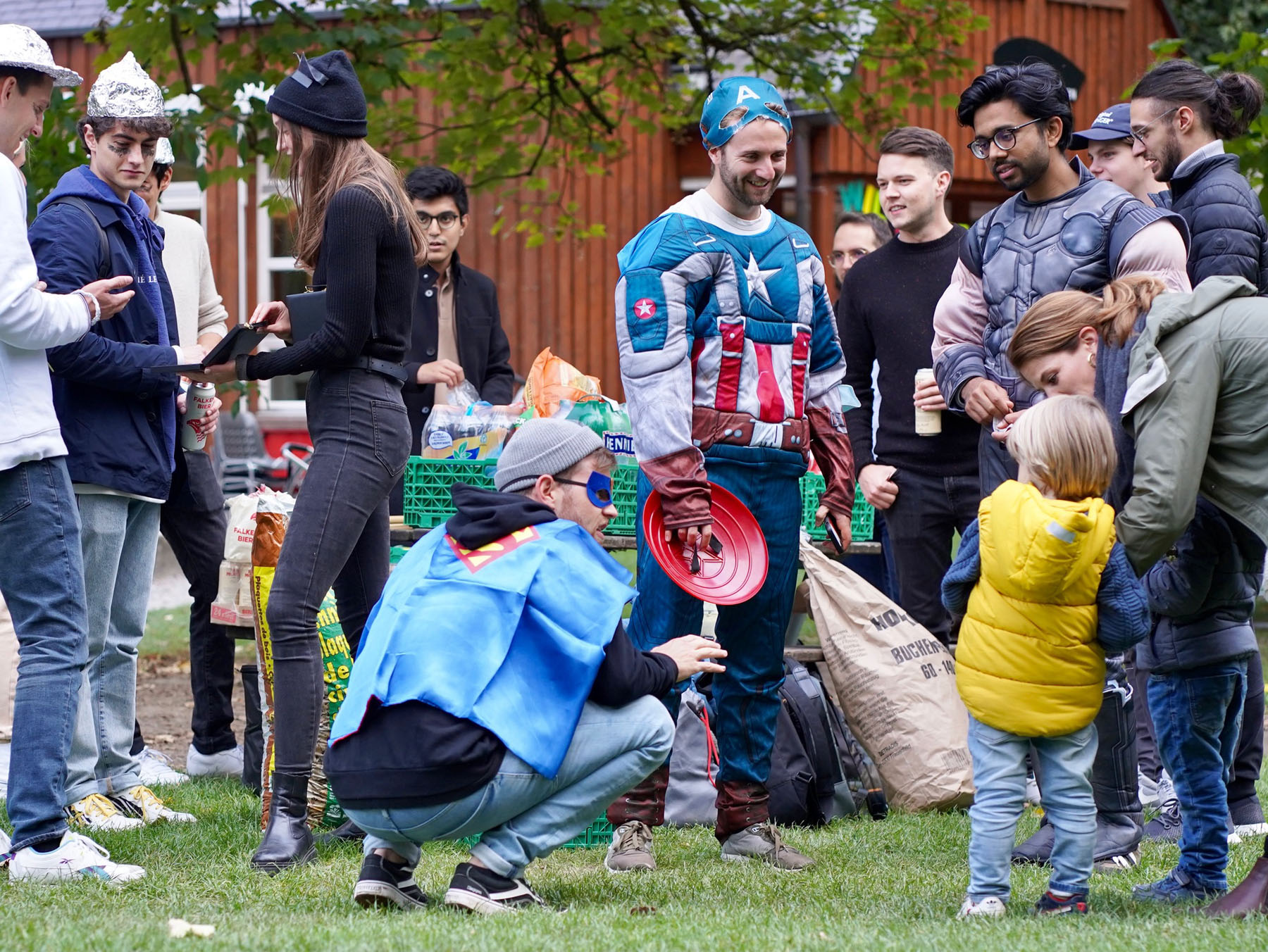 Enlarged view: Students dressed as superheroes talk to locals.